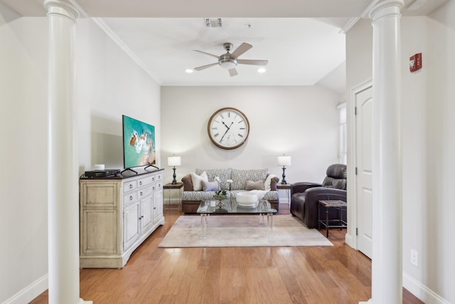 living room featuring lofted ceiling, light wood-type flooring, ornamental molding, ceiling fan, and decorative columns