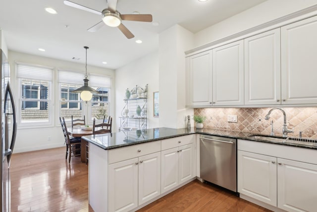 kitchen with white cabinetry, appliances with stainless steel finishes, kitchen peninsula, and sink