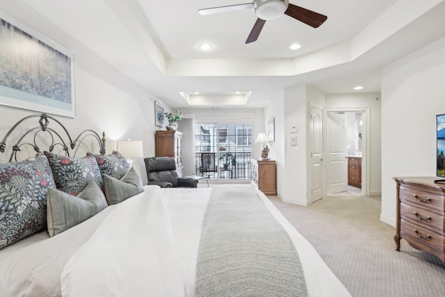 carpeted bedroom featuring a raised ceiling, connected bathroom, access to outside, and ceiling fan