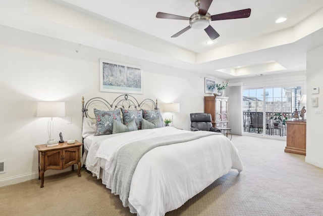 carpeted bedroom featuring a raised ceiling, access to exterior, and ceiling fan