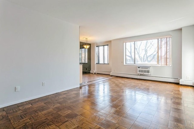 unfurnished room with a wall mounted air conditioner and a baseboard radiator