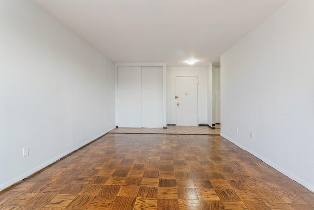 empty room with dark parquet flooring