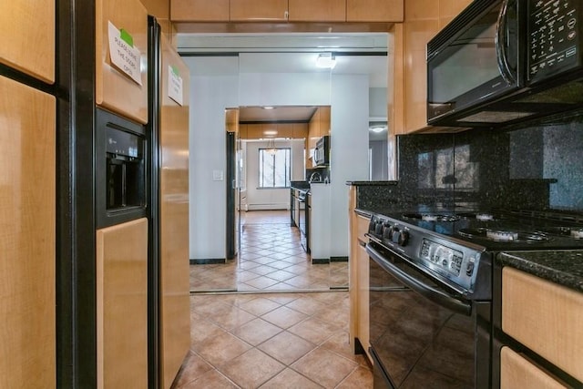 kitchen featuring black appliances, light tile patterned floors, dark stone counters, decorative backsplash, and a baseboard heating unit