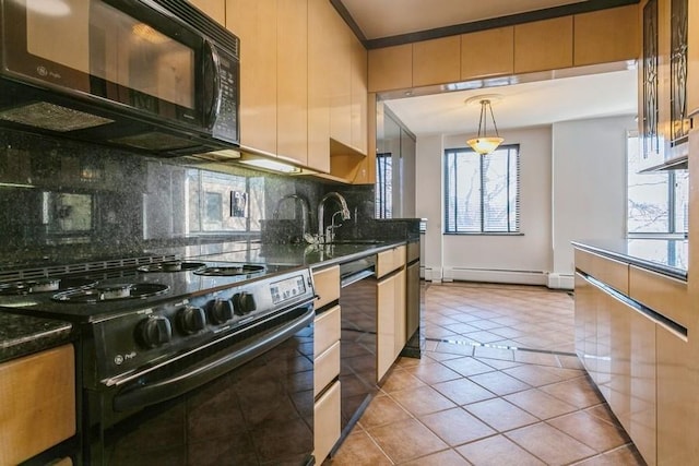 kitchen featuring sink, black appliances, dark stone countertops, pendant lighting, and a baseboard heating unit