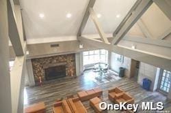 living room featuring beam ceiling and a fireplace