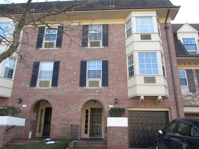 view of front of property featuring a garage and cooling unit