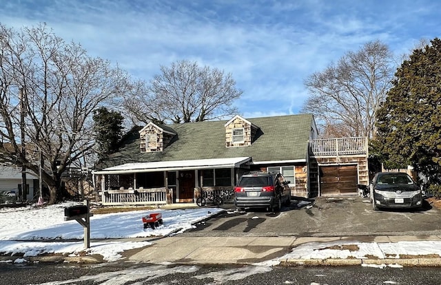 cape cod-style house with a garage and a porch