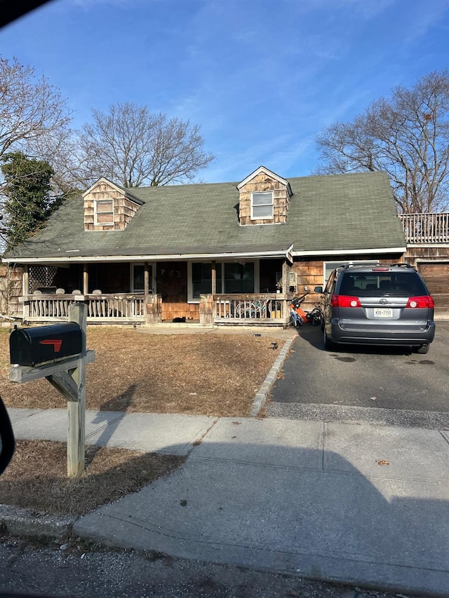 new england style home featuring covered porch