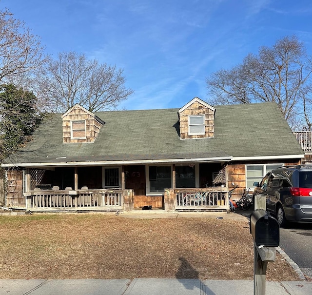 new england style home featuring covered porch