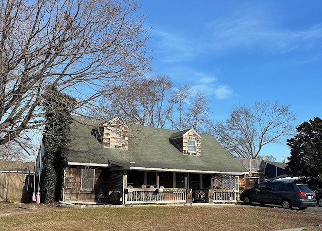 cape cod house with a porch and a front yard