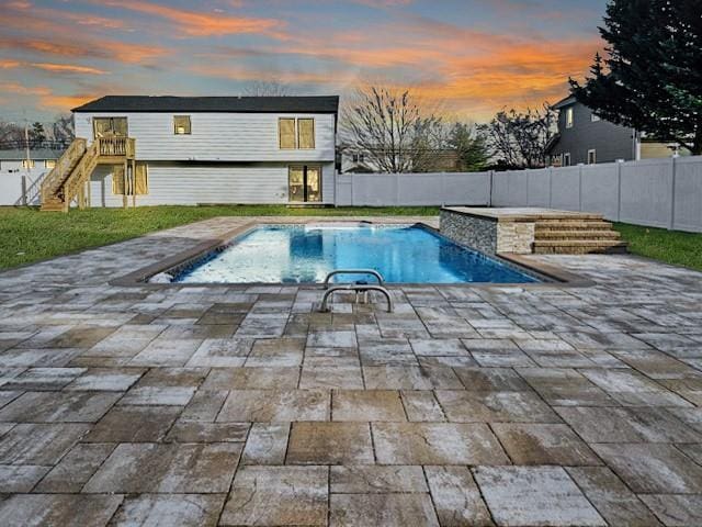 pool at dusk with a patio area