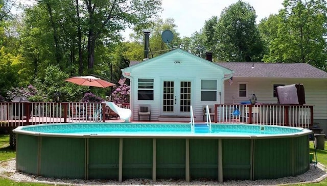 view of pool featuring french doors and a wooden deck