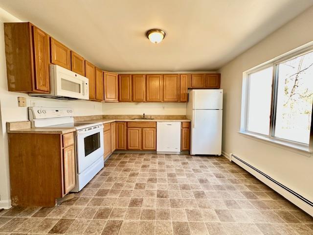 kitchen with sink, white appliances, and a baseboard radiator