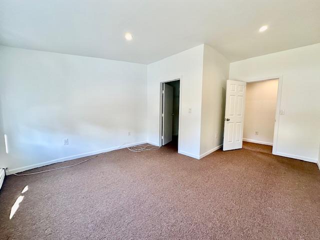 unfurnished bedroom with dark colored carpet