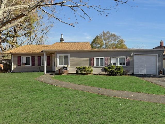 ranch-style home with a garage and a front lawn