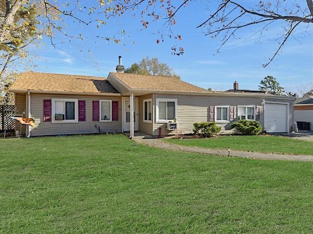 single story home with a garage and a front lawn