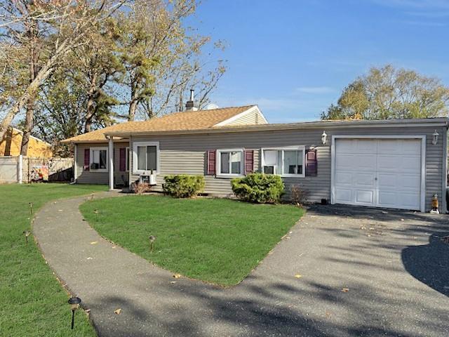 ranch-style house featuring a garage and a front yard