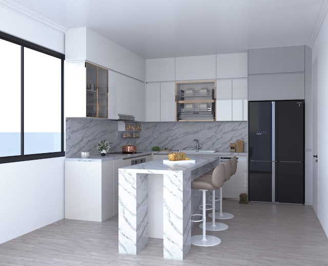 kitchen with black appliances, modern cabinets, backsplash, a kitchen island, and white cabinets