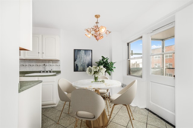 dining space featuring a notable chandelier, sink, and light tile patterned floors