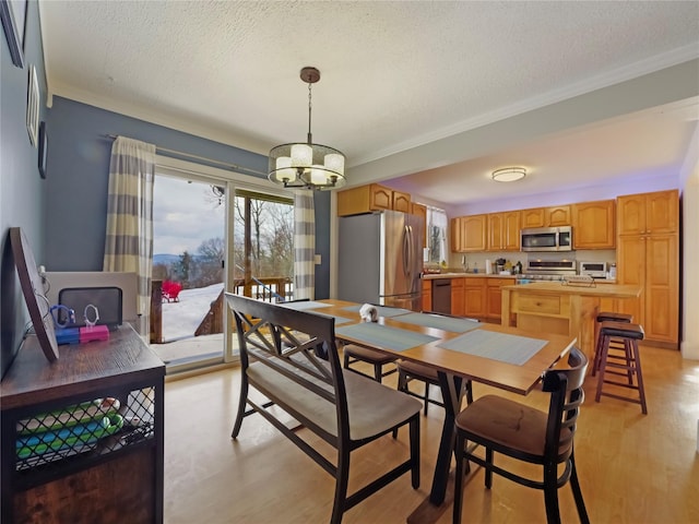 dining space with ornamental molding, a chandelier, light hardwood / wood-style flooring, and a textured ceiling