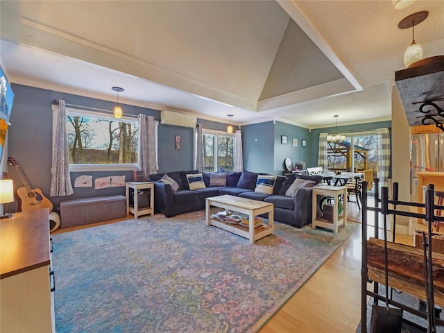 living room featuring hardwood / wood-style flooring, crown molding, vaulted ceiling, and an inviting chandelier