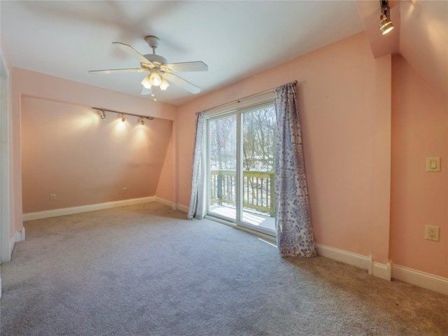 carpeted empty room featuring ceiling fan and track lighting