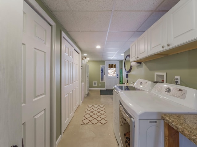 laundry room with washer and clothes dryer and cabinets