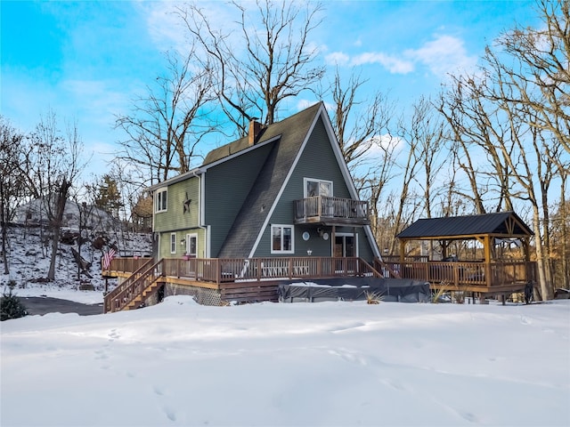 snow covered rear of property featuring a gazebo and a balcony