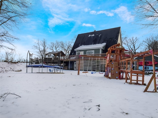 snow covered property with a trampoline and a playground