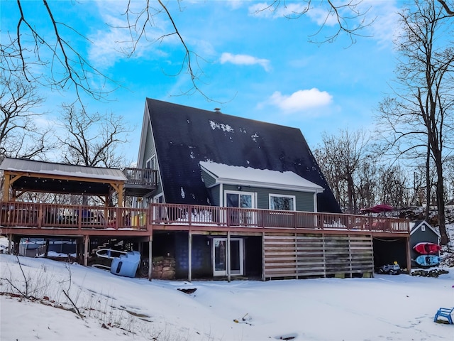 snow covered house with a wooden deck and a gazebo