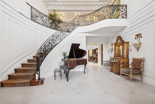 foyer entrance featuring a towering ceiling and ornamental molding