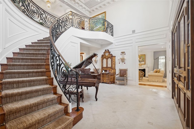 foyer with a towering ceiling and ornamental molding