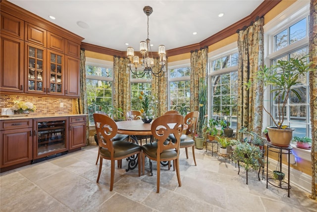 dining room featuring crown molding, wine cooler, and an inviting chandelier