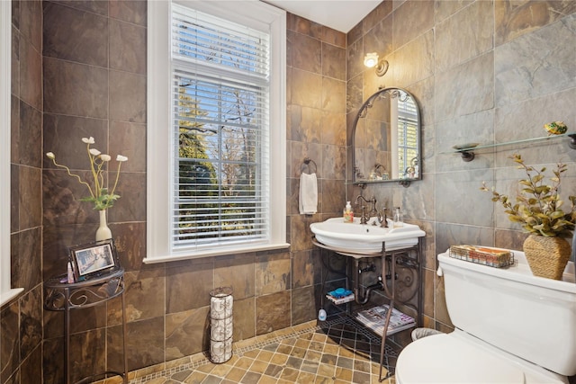 bathroom with tile walls, plenty of natural light, and toilet