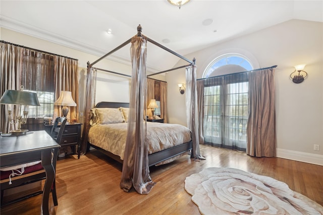 bedroom with hardwood / wood-style flooring, crown molding, and vaulted ceiling