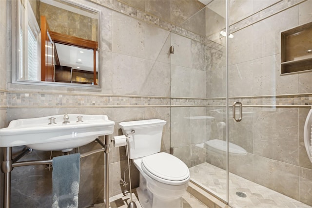 bathroom featuring sink, an enclosed shower, and toilet