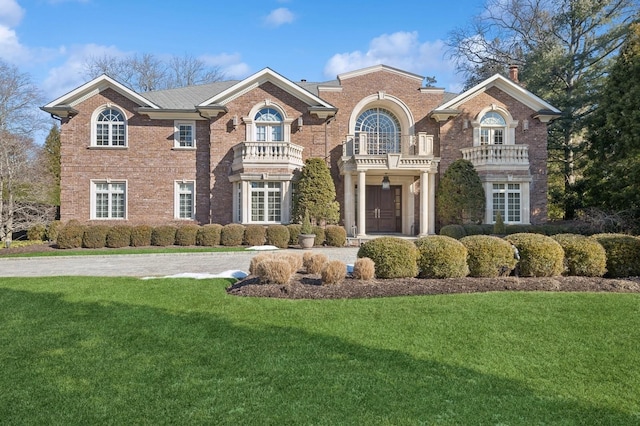 view of front of property featuring a front lawn and a balcony