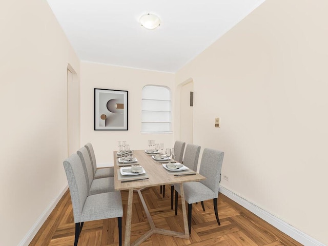 dining space with built in shelves and parquet flooring