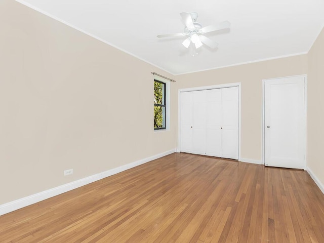 unfurnished bedroom featuring hardwood / wood-style flooring, crown molding, and ceiling fan