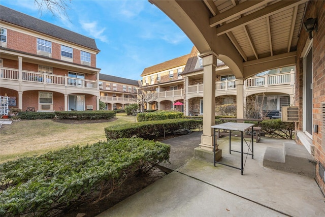 view of property's community featuring a patio area and a lawn