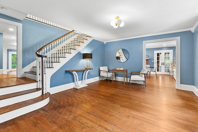 living area with hardwood / wood-style floors, crown molding, and french doors