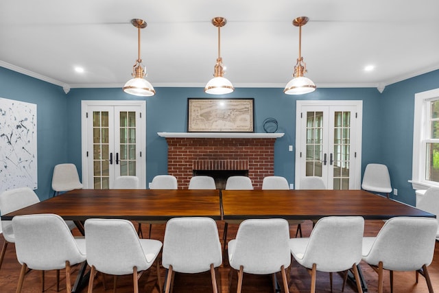 dining space featuring crown molding, a brick fireplace, and french doors