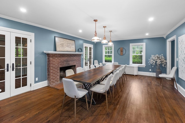 dining room with french doors, a fireplace, dark hardwood / wood-style flooring, and crown molding