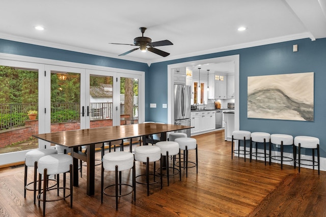 dining space with sink, dark hardwood / wood-style flooring, ceiling fan, crown molding, and french doors