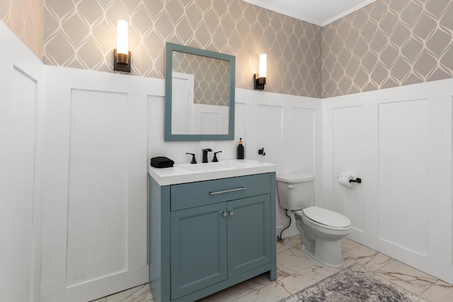 bathroom with vanity, crown molding, and toilet