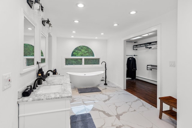 bathroom with vanity, a tub, and a baseboard heating unit