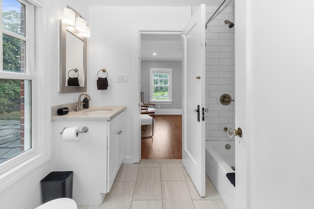 bathroom with tiled shower / bath combo and vanity