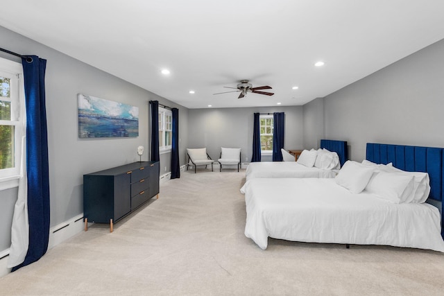 bedroom featuring ceiling fan, light colored carpet, and a baseboard heating unit