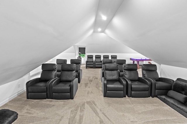 carpeted home theater room featuring vaulted ceiling