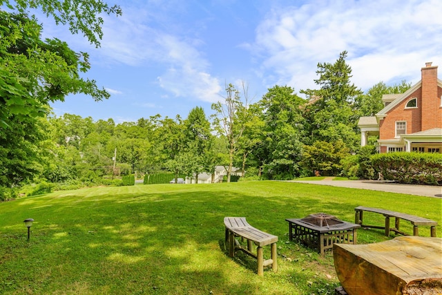 view of home's community with a lawn and a fire pit